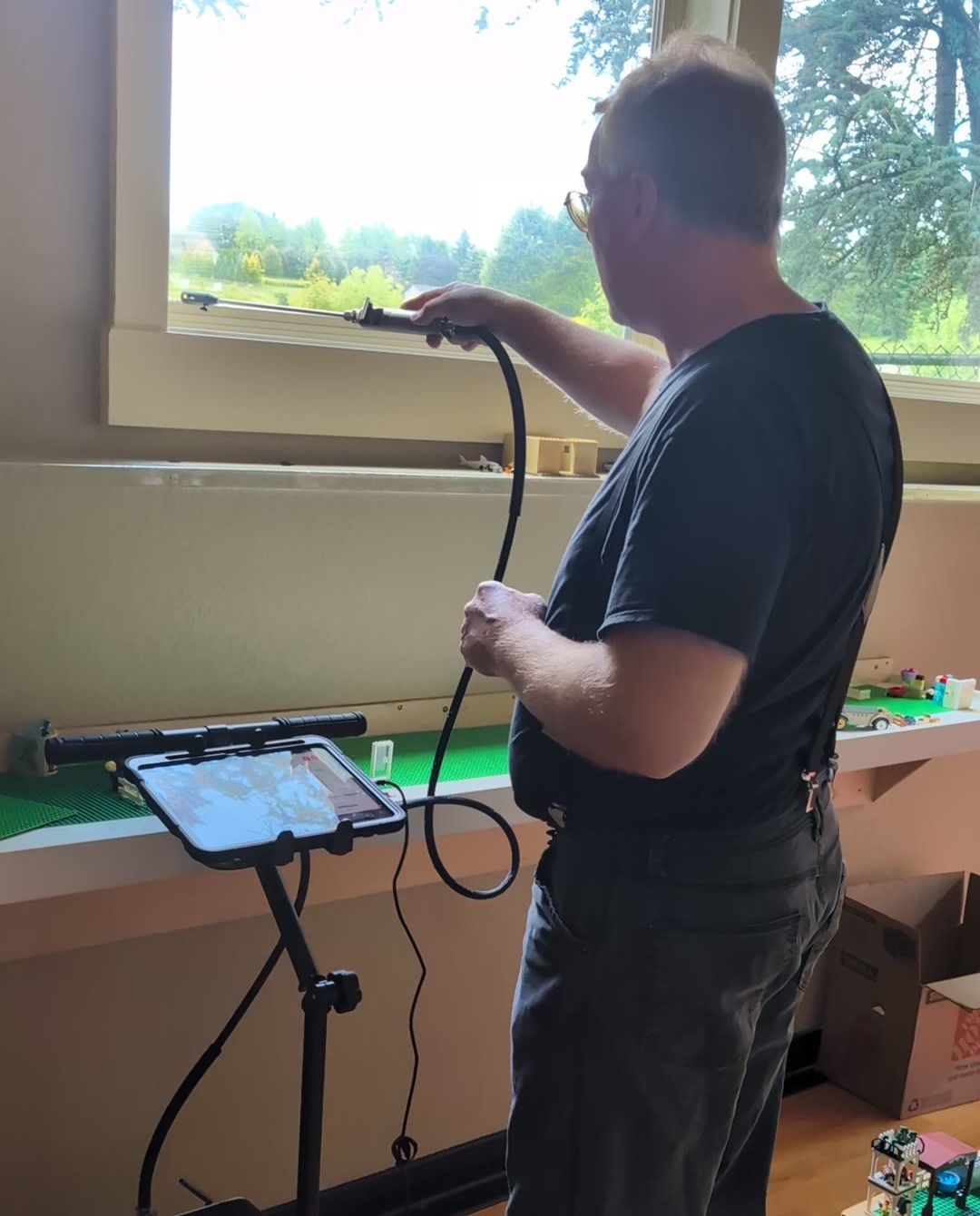 IllumenAir technician performing room-by-room indoor air quality testing with a real-time analyzer